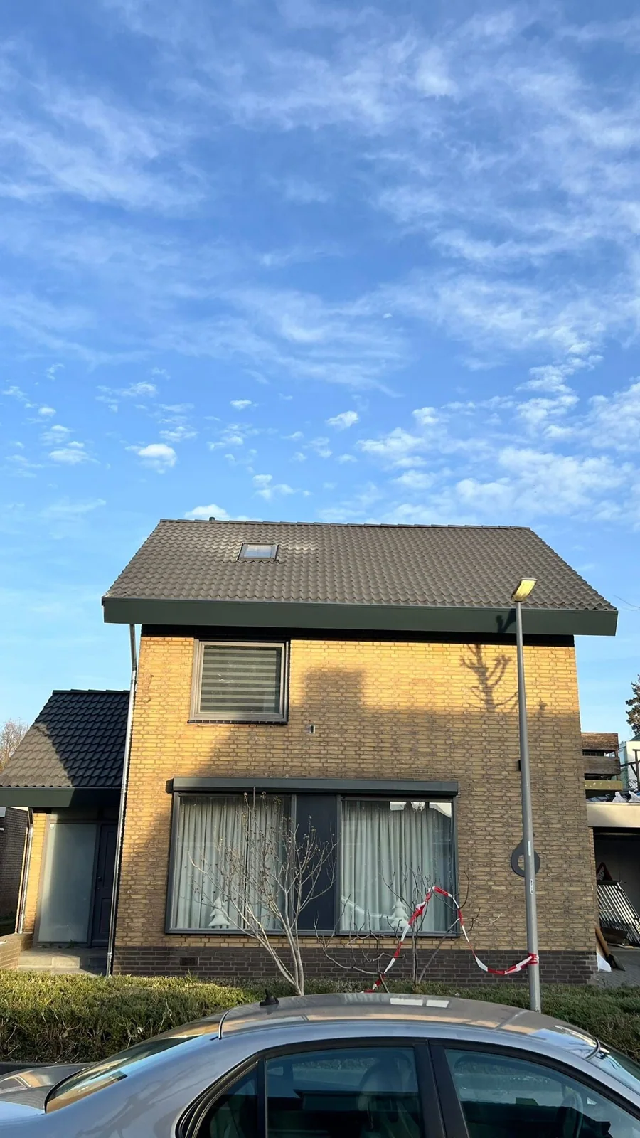 Woning met vernieuwd dak onder een blauwe lucht